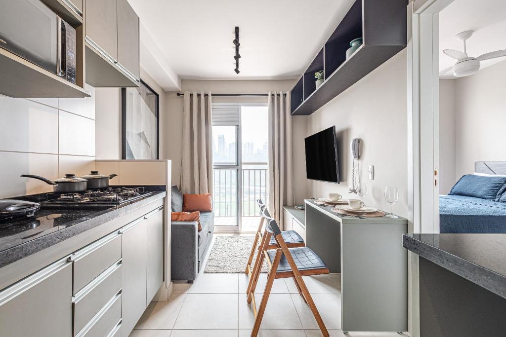 a kitchen with a stove top oven next to a living room at Laguna 1809 - Seu espaço em SP in Sao Paulo