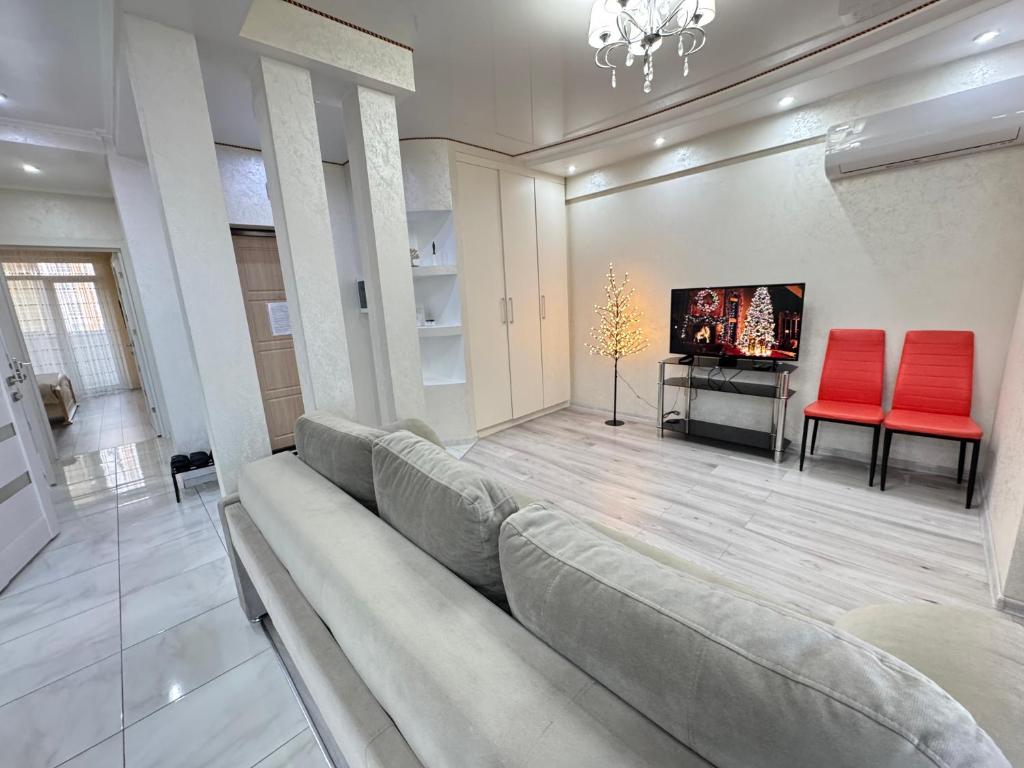 a living room with a couch and two red chairs at For Family Full Apartment near AirPort in Chişinău