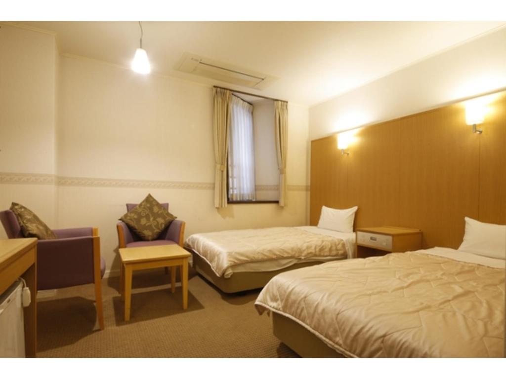 a hotel room with two beds and a chair at Hotel Hanakomichi - Vacation STAY 27580v in Nara