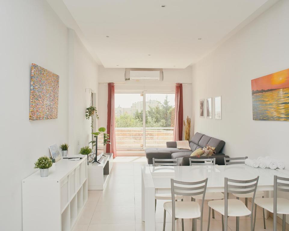 Una sala de estar blanca con una mesa y sillas. en Le Julien by Shmoo, en San Julián