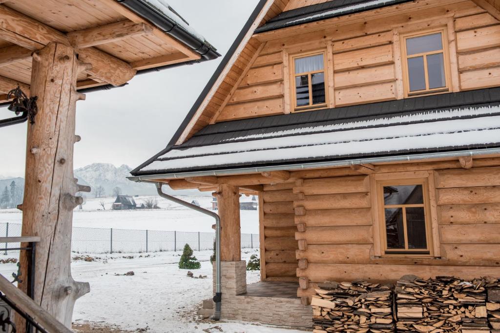 Cabaña de madera con nieve en el techo en Domek NBD-bafia, en Zakopane