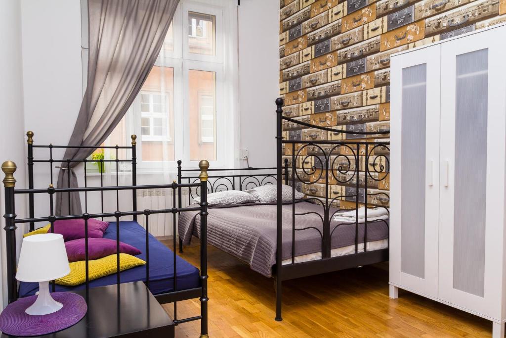 a bedroom with a black bed and a brick wall at Retro Hostel in Poznań