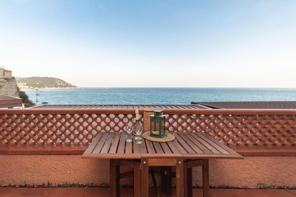a wooden table on a balcony with the ocean at C22 Beachfront Villa - SPA BATH, POOL, PRIVATE BEACH, PARKING FREE in Marina dʼAndora