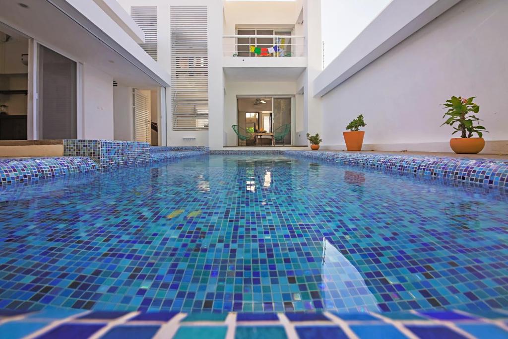 a swimming pool with blue tiles in a building at Casa CAMPANA, Privada, Piscina Privada, 3 Cuadras Malecón in Cozumel