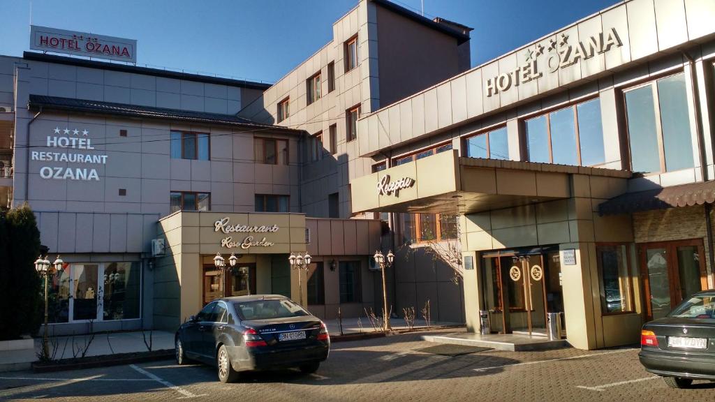 a car parked in a parking lot in front of a building at Hotel Ozana in Bistriţa