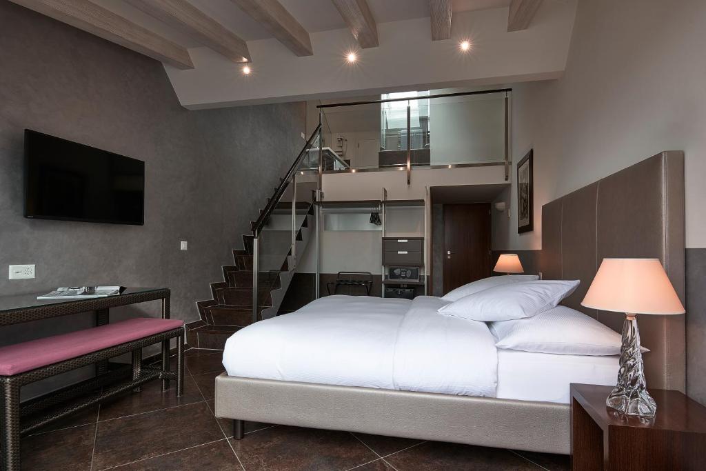 a bedroom with a white bed and a staircase at Hotel d'Allèves in Geneva