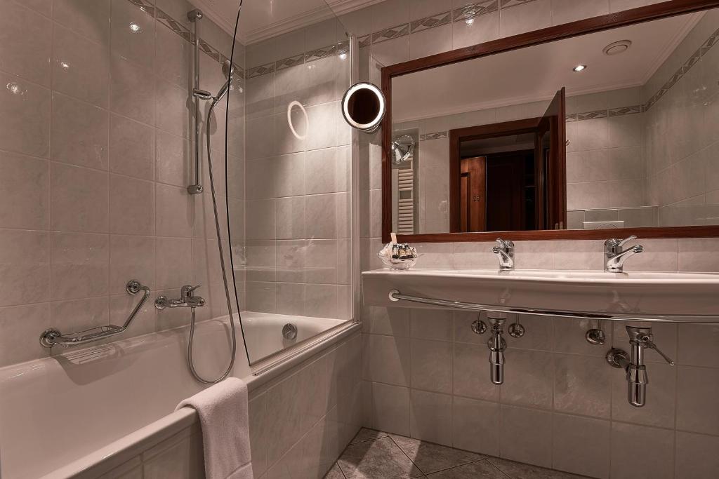a bathroom with a shower and a sink and a tub at Hotel d'Allèves in Geneva