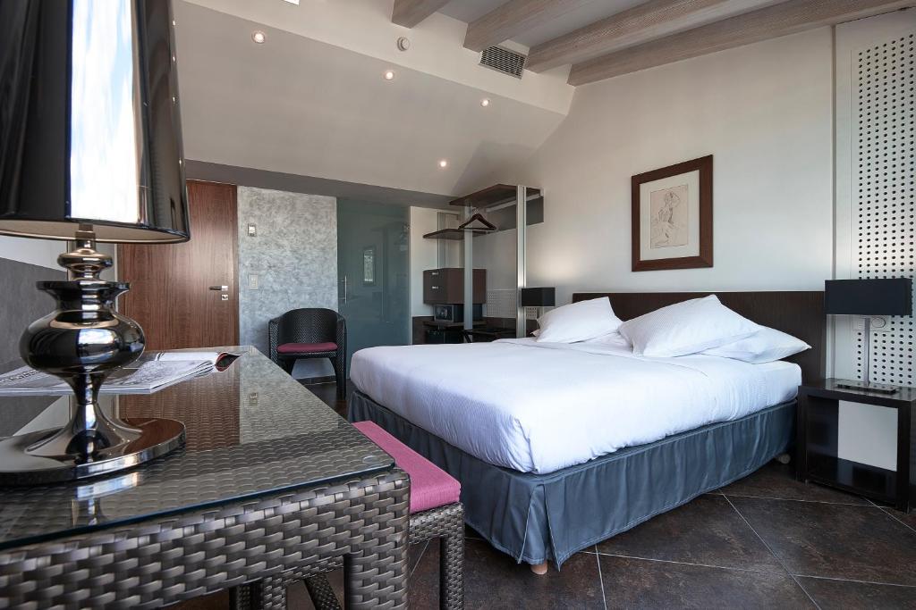 a hotel room with a bed and a desk at Hotel d'Allèves in Geneva