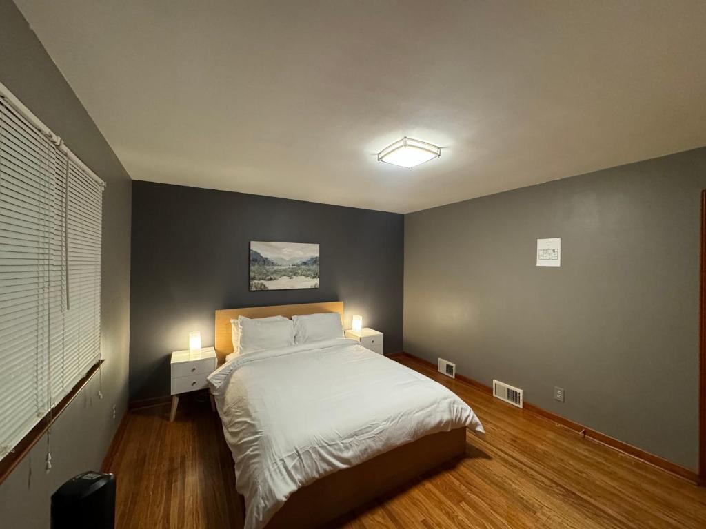 a bedroom with a bed with two lights on it at Charming Cape Cod Bungalow at Niagara Falls, NY! in Niagara Falls