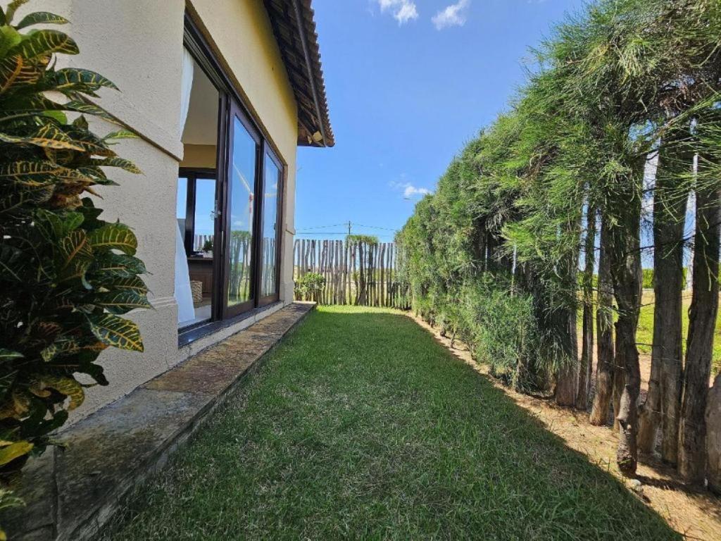 an empty yard next to a house with trees at Villa Formentera - Casa 08 by The Coral Beach Resort in Trairi