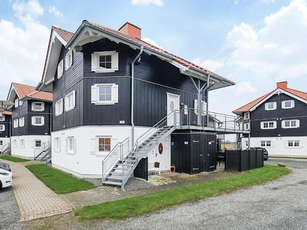 a large black and white house with a staircase at 4 star holiday home in Bogense-By Traum in Bogense
