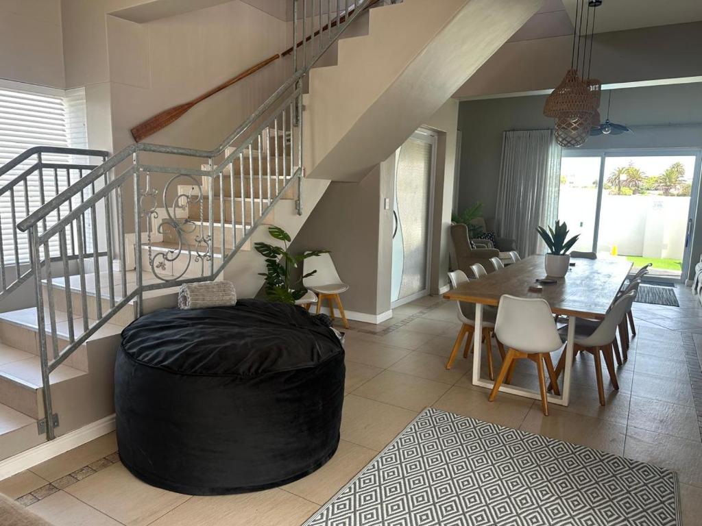 a large living room with a table and a staircase at Luxury Beachfront Villa in Langebaan