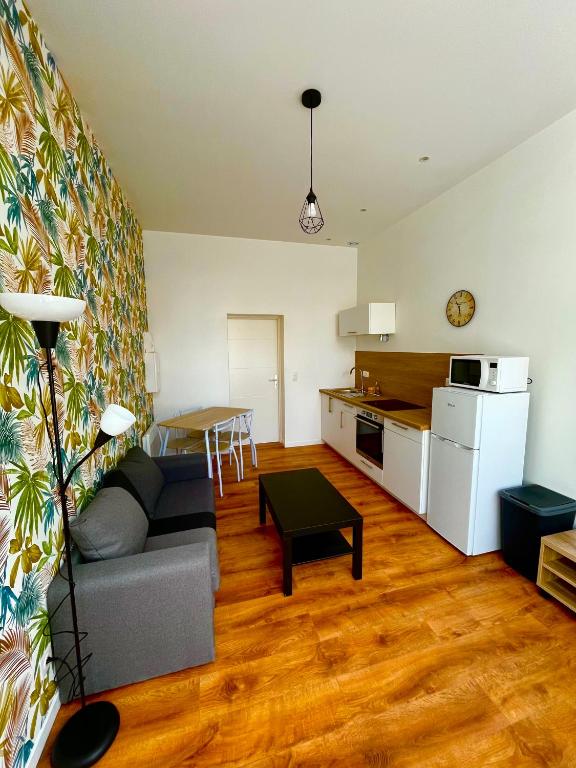 un salon avec un canapé et une cuisine dans l'établissement Les Perles d'Opale - Le Petit Sablé - Hyper centre, à Boulogne-sur-Mer