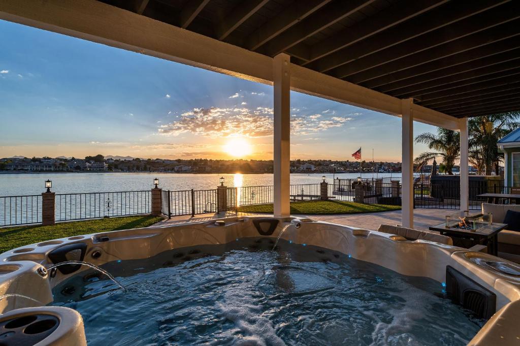 un patio con bañera de hidromasaje y vistas al agua en The Lakefront Oasis, en Victorville