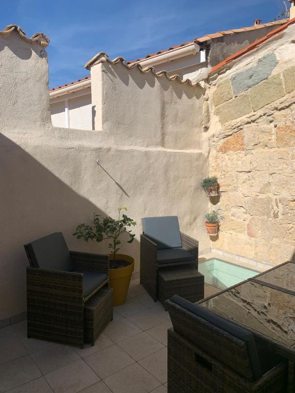 a patio with two chairs and a pool at Quiet street in old Mèze - terrace, 250m to beach in Mèze