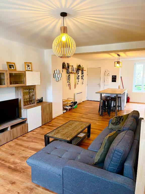 un salon avec un canapé bleu et une table dans l'établissement Les Perles d'Opale - L'Eclat des Flots - Duplex, à Boulogne-sur-Mer