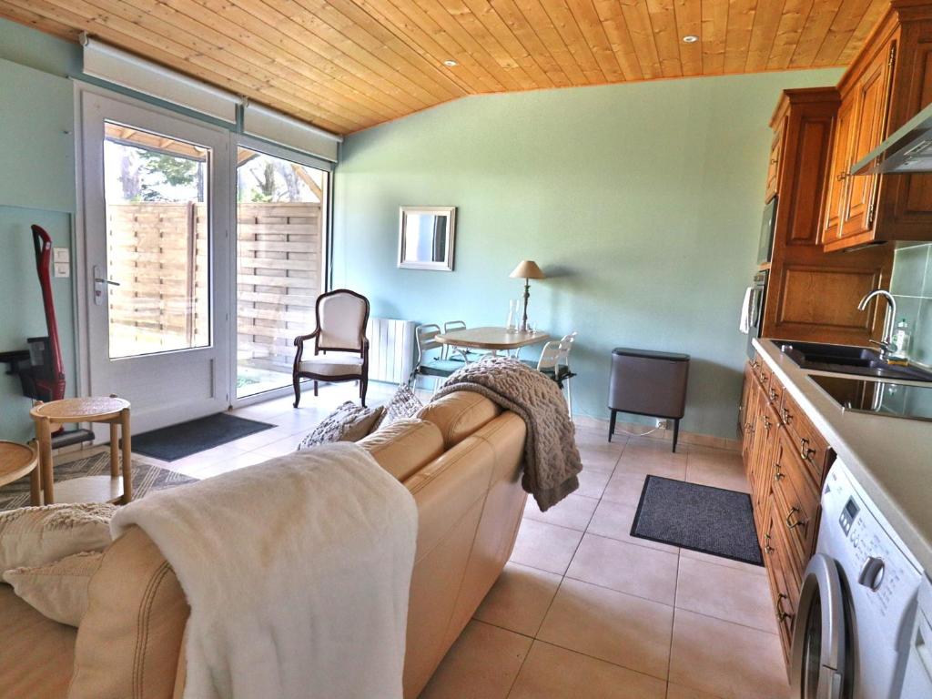 a kitchen and living room with a couch and a table at Appartement avec jardin privatif et équipements modernes - FR-1-813-9 in Groix