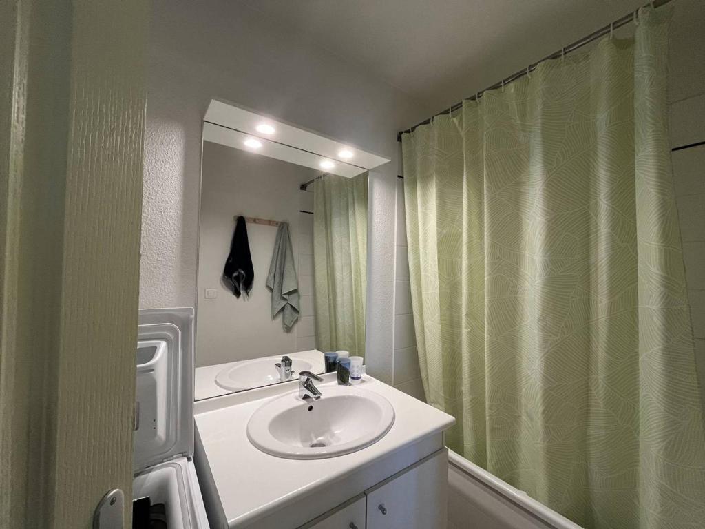 une salle de bain avec un lavabo et un rideau de douche dans l'établissement Charmant appartement avec 2 chambres à Cauterets - FR-1-812-127, à Cauterets