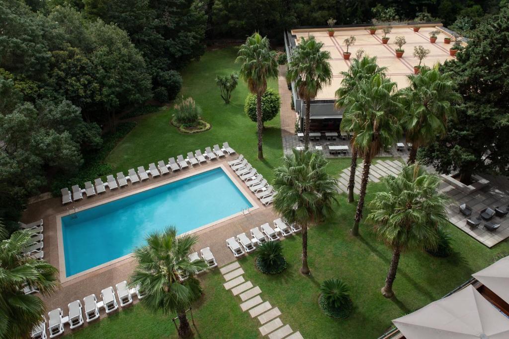 an aerial view of a resort with a swimming pool and palm trees at Lisbon Marriott Hotel in Lisbon