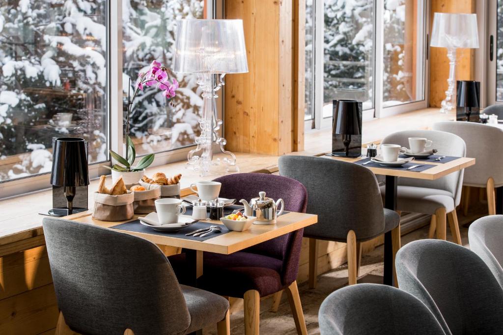 a restaurant with two tables and chairs with food on them at Le Pic Blanc in L'Alpe-d'Huez