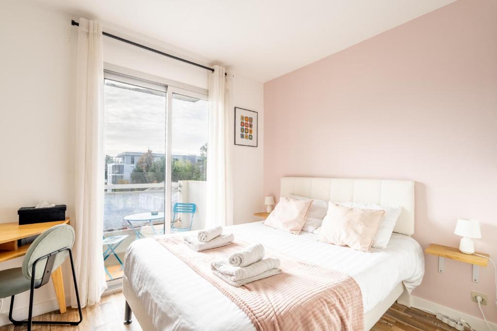 une chambre avec un grand lit blanc avec des serviettes dessus dans l'établissement Les Verrières・Studio à 400m de la mer・Netflix, à Saint-Nazaire