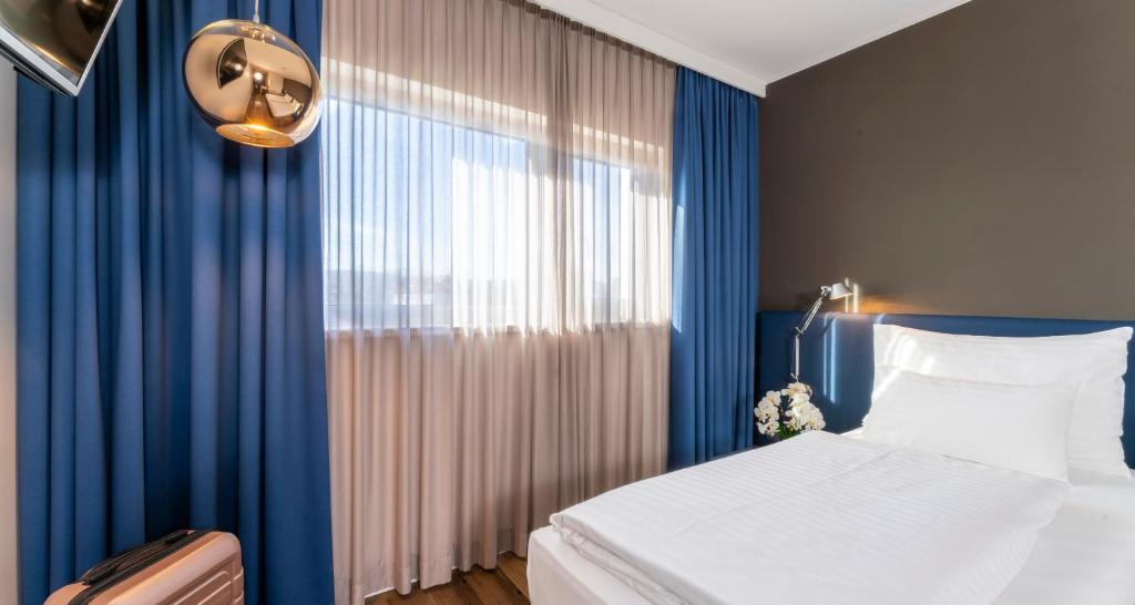 Cama o camas de una habitación en PLAZA INN Graz