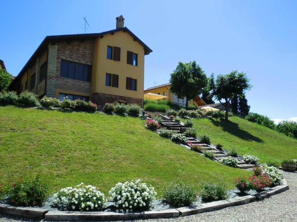 a house on a hill with flowers in front of it at Ca' Villa Club Agriturismo in Gabiano