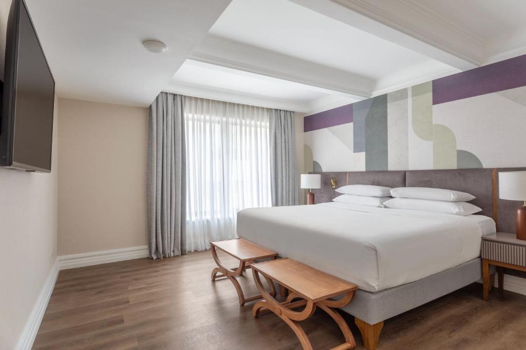 a bedroom with a large white bed and a tv at Buenos Aires Marriott in Buenos Aires