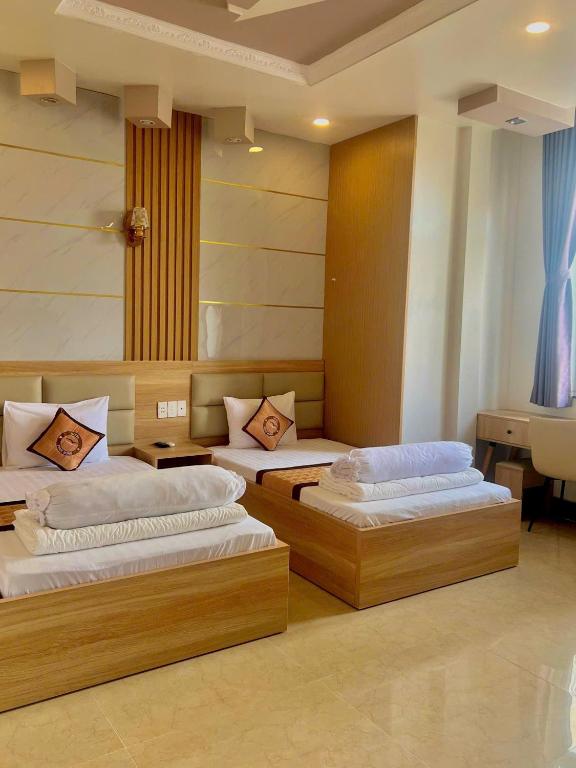 a room with three beds in a room at Phuc Hung Hotel in Rạch Giá