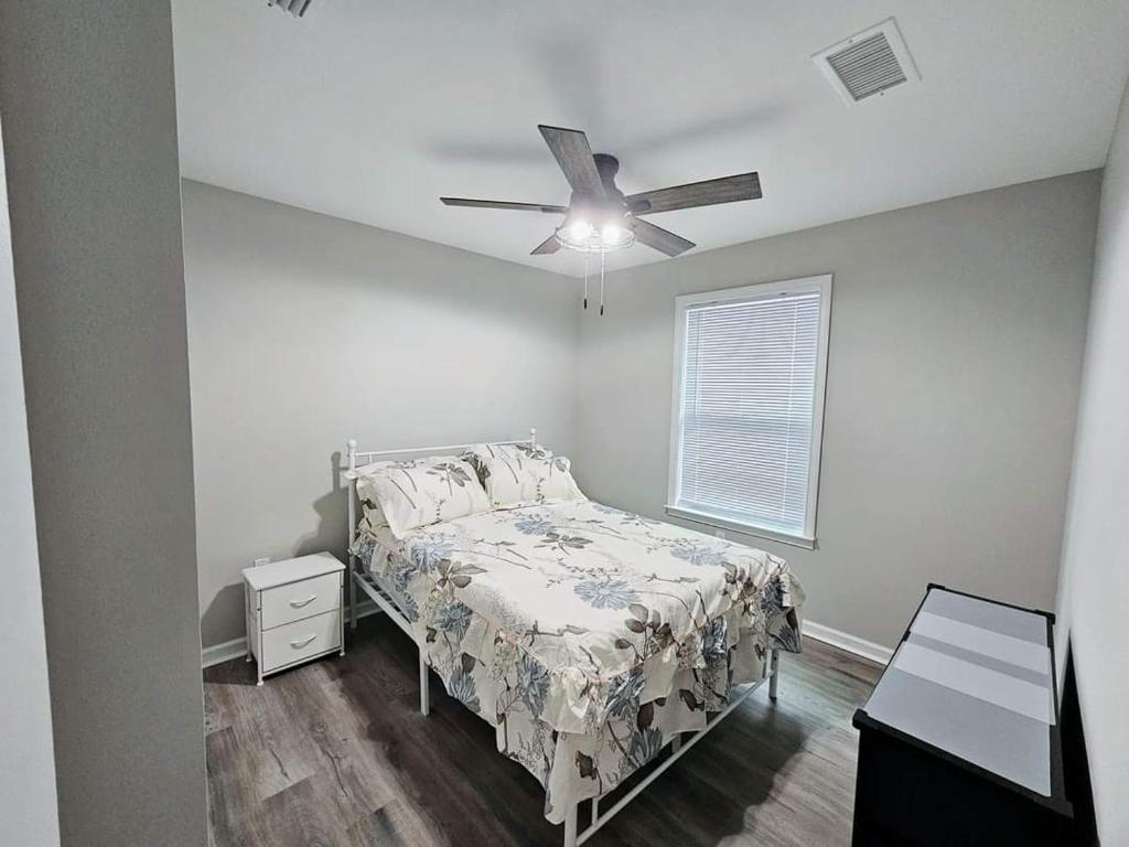 Un dormitorio con una cama y un ventilador de techo. en Come feel home away from home, en Crawfordville