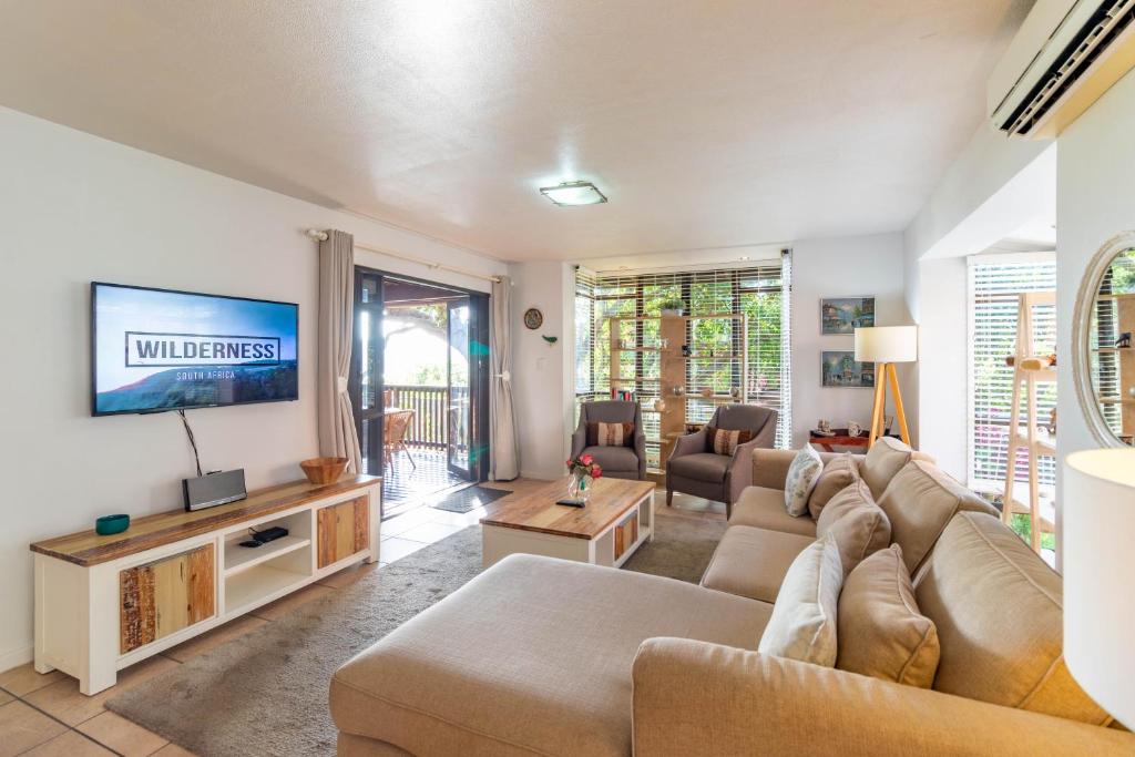 un salon avec un canapé et une télévision dans l'établissement Central Wilderness Bliss - Sleeps 6 - Beach & Lagoon, à Wilderness