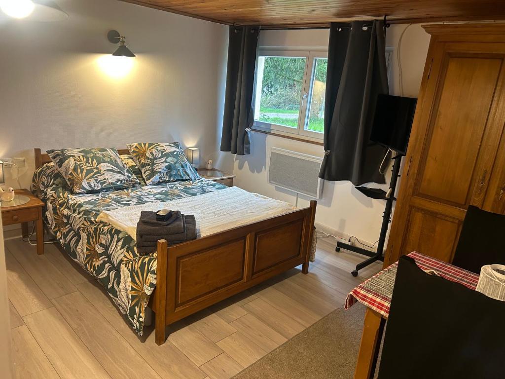 une chambre avec un lit, un canapé et une télévision dans l'établissement Nuit à la campagne, à Assenoncourt