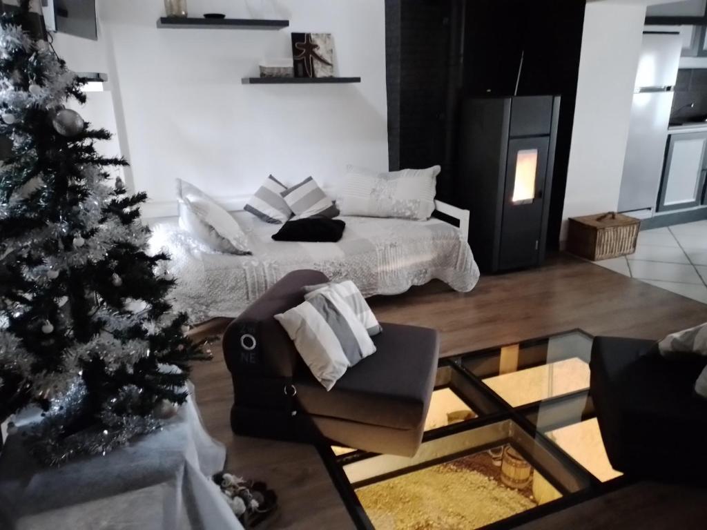 - un salon avec un arbre de Noël et un lit dans l'établissement La Cabourotte, ancien fournil, classé 3 étoiles, à Herpelmont