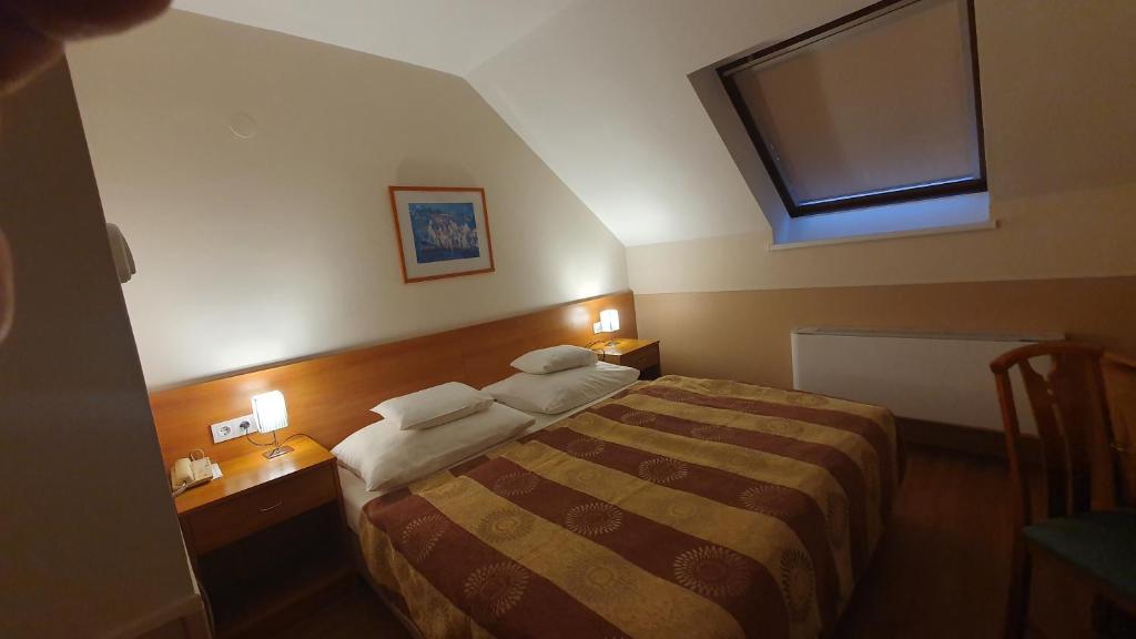 Łóżko lub łóżka w pokoju w obiekcie Hotel Baross