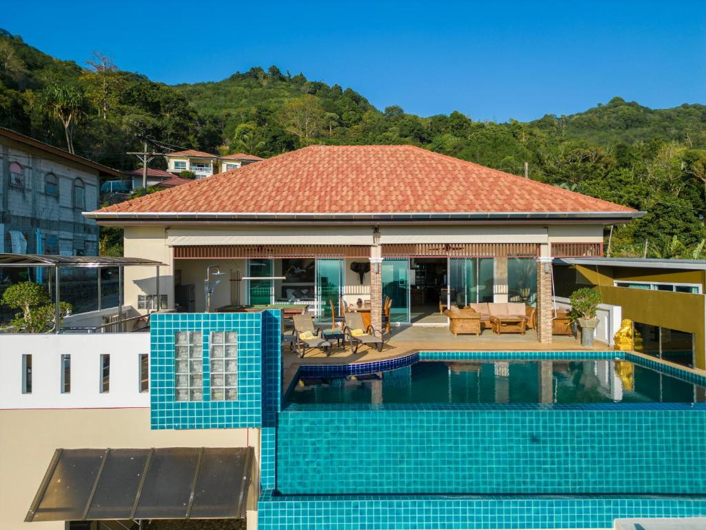a house with a swimming pool in front of it at Karon Bliss: 4 Bedroom Haven in Karon Beach