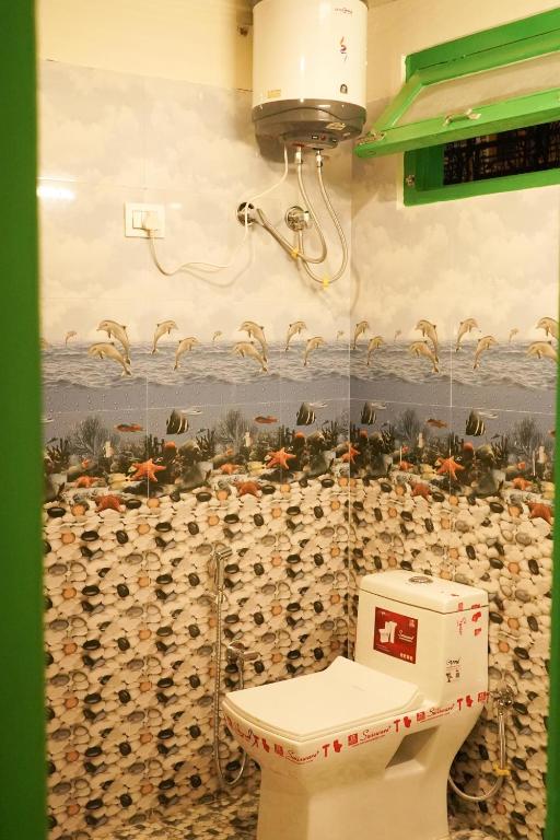 bagno con servizi igienici e parete di bottiglie di vino di Nomadic Den Manali a Manāli