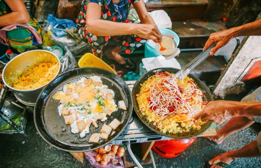 un grupo de personas preparando comida en una mesa en Clara home, en Da Nang