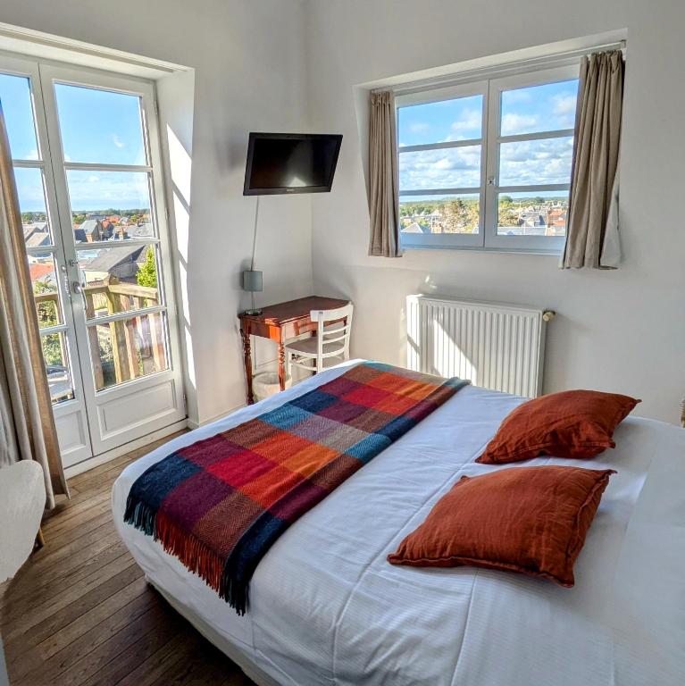 une chambre avec un grand lit et deux fenêtres dans l'établissement Hotel Restaurant Les Tourelles, au Crotoy