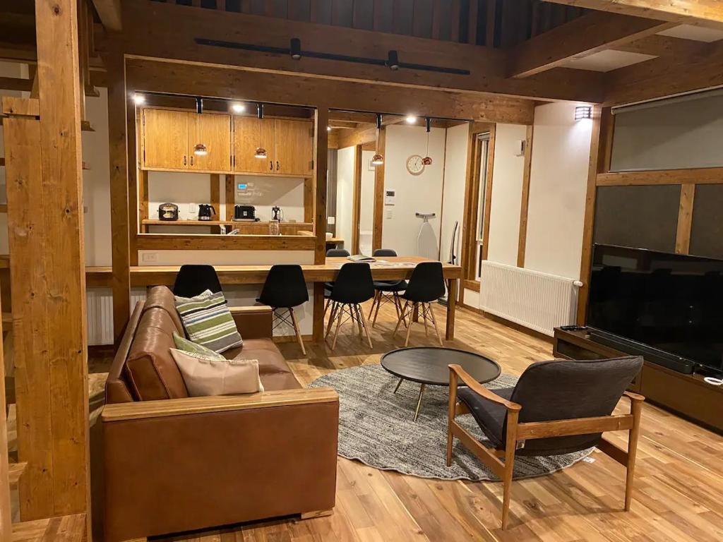 ein Wohnzimmer mit Sofa und Tisch in der Unterkunft Niseko Annupuri Royal Chalet in Niseko