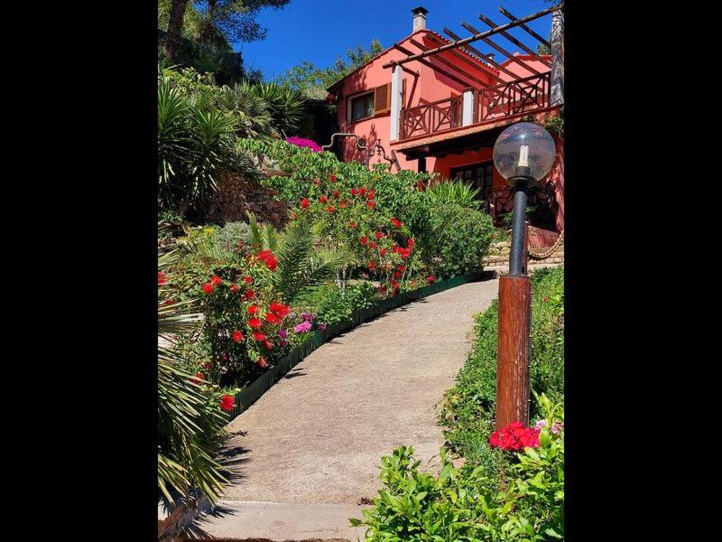 a walkway in a garden with flowers and a street light at Villetta Blu in Rio nellʼElba