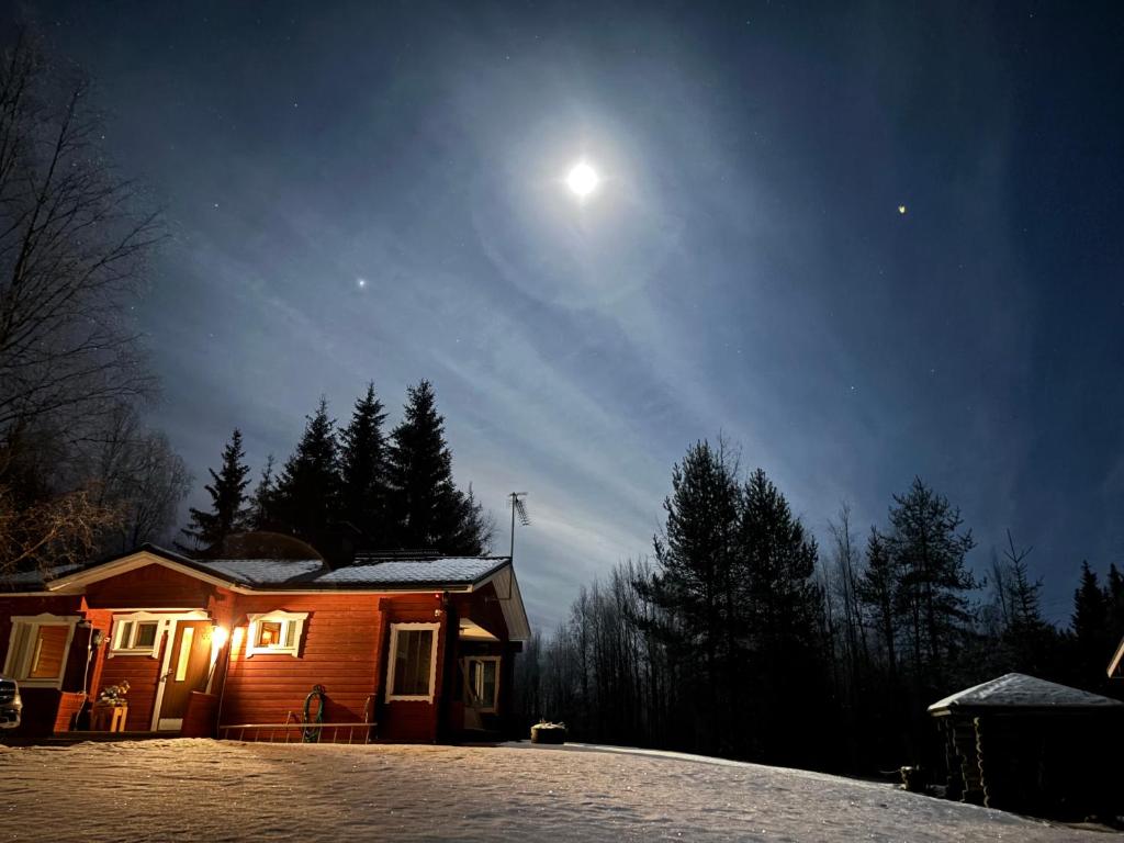 a house at night with the moon in the sky at Villa Oitola I Parking I Sauna I Wifi I Lake I Rural I Forest I Ideal for Aurora spotting in Sonka