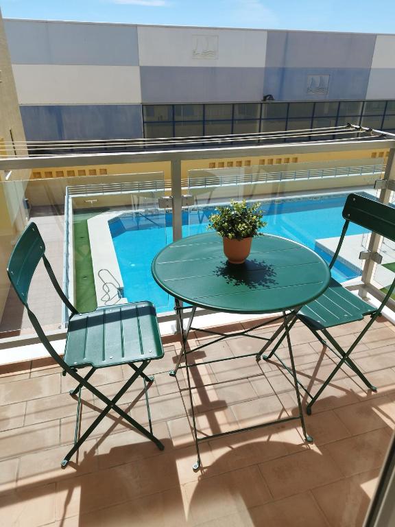 a table and chairs on a balcony with a pool at Carnaval 16 in Isla Cristina