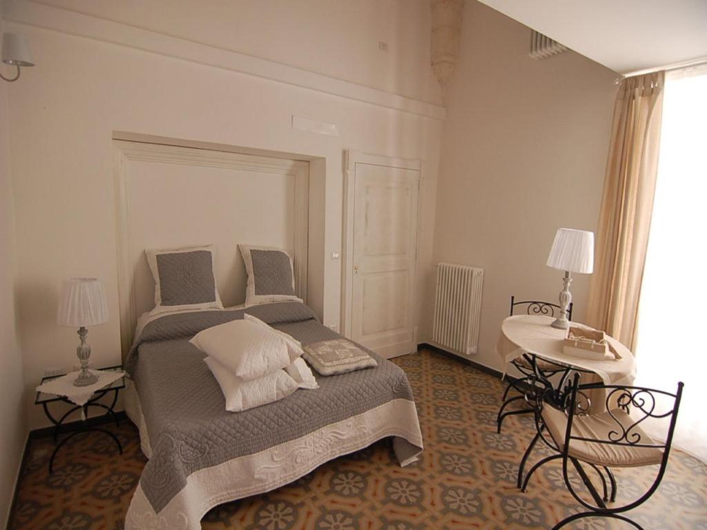 een slaapkamer met een bed en een tafel met 2 lampen bij Domus Alba in Martina Franca
