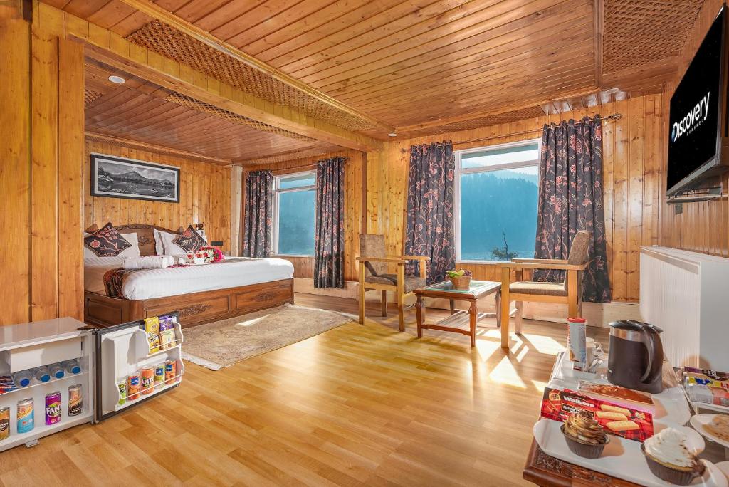 ein Schlafzimmer mit Bett und Schreibtisch und eine Küche in der Unterkunft Marina Drung Waterfall By Stay Pattern in Gulmarg
