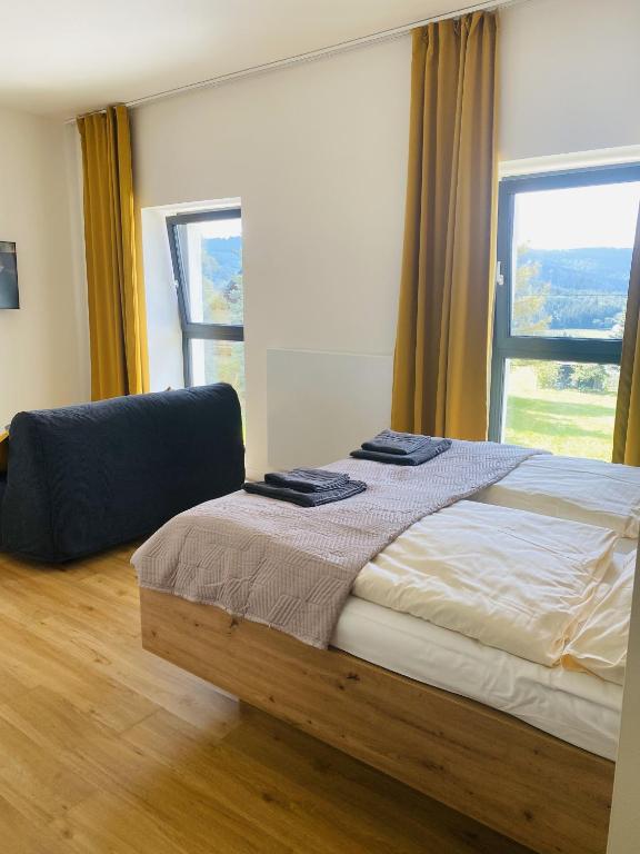 a bedroom with a bed and a large window at Apartment Arber Šumava in Čachrov