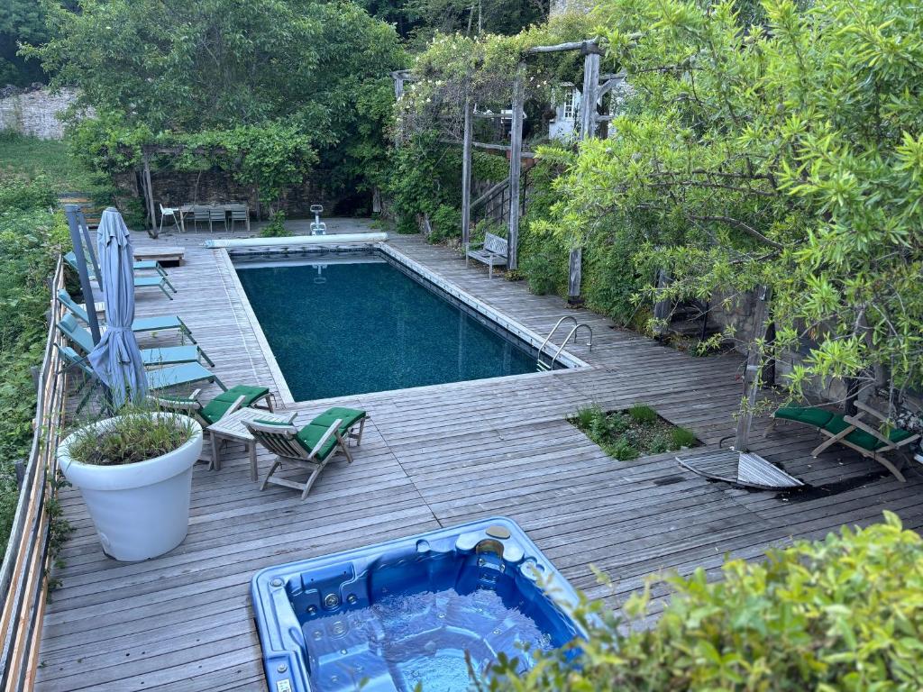 a swimming pool on a wooden deck next to at Fount Estremiero - Chambres & tables d'hôtes in Castans