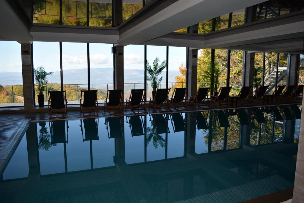 una piscina con sillas en un edificio con ventanas en Okili apartman S11 Milmari resort Kopaonik, en Kopaonik