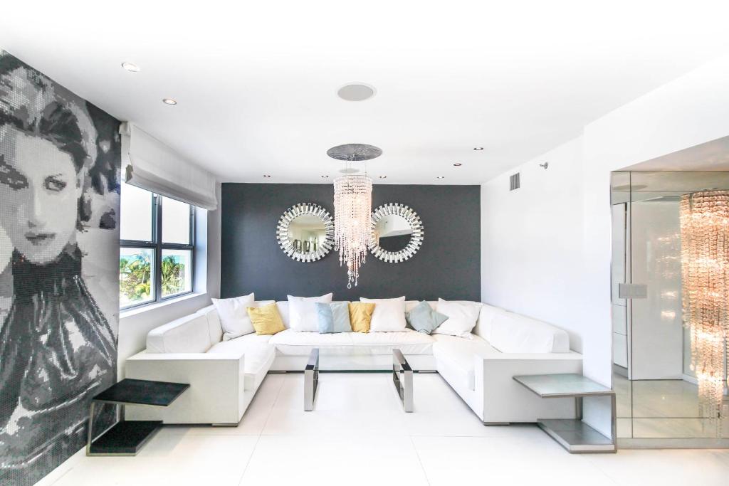 sala de estar con sofá blanco y lámpara de araña en Casa Grande Suites on Ocean Drive, en Miami Beach