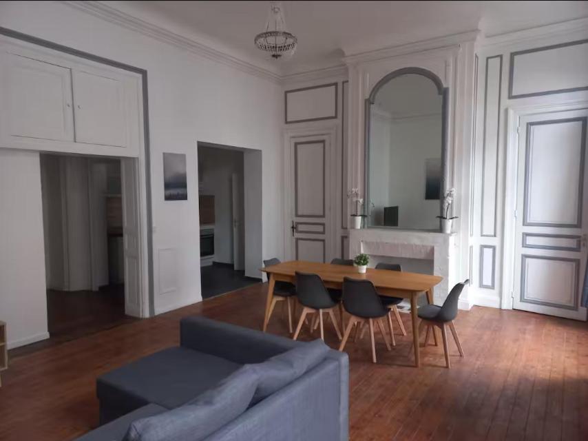 un salon avec un canapé, une table et des chaises dans l'établissement Spacieux no6 Carnot beau T3 direct métro, à Tourcoing