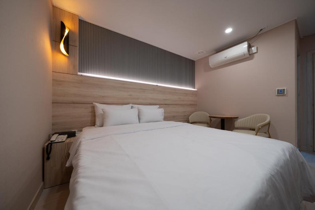 Postel nebo postele na pokoji v ubytování Hwajeong Jun Hotel